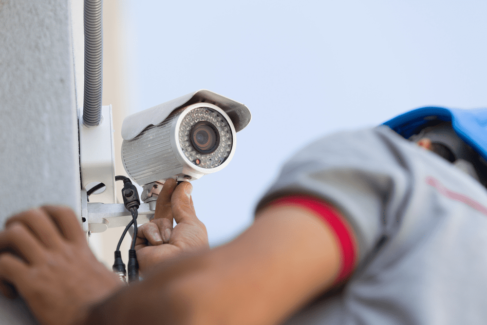 man turning on security camera fed by electric battery
