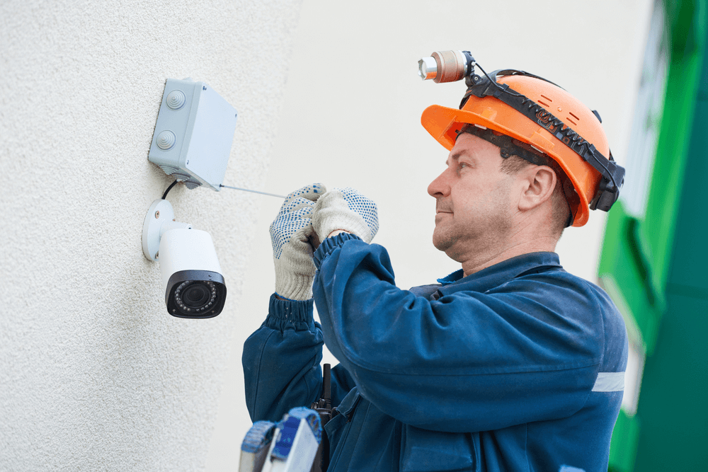 a man installing a wireless and wirefree security camera a man installing a wireless and wirefree security camera